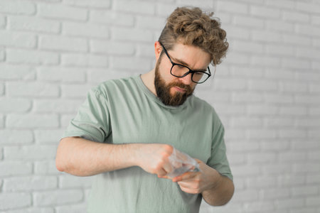 Young attractive man assembles furniture - handwerker and interior objects concept