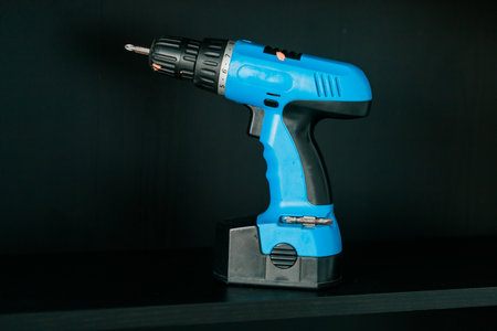 Cordless screwdriver or blue cordless drill stands on the shelfの写真素材
