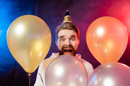 Joyful bearded man celebrates something happy playful mood and winner raises fists. Party time and holiday conceptの写真素材