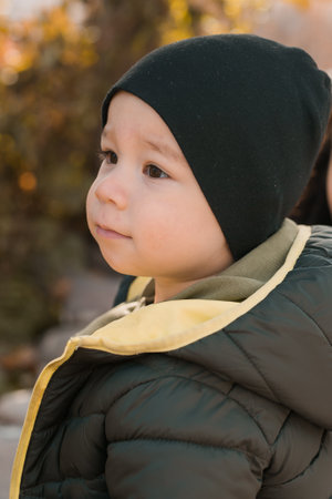 Little child boy playing in autumn park in Asia. Toddler cute Korean kid portrait close-up outdoorsの写真素材