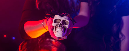 Halloween banner witch making magic with scull in halloween night copy space. Magic, holidays and mystic concept.の写真素材