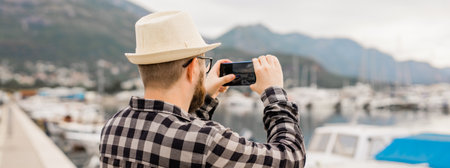 Traveller millennial man taking pictures of luxury yachts marine during sunny day - travel and...