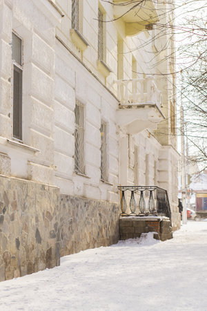 Street with building cold weather. Snow day in winter. Building in city center covered with snow.の写真素材