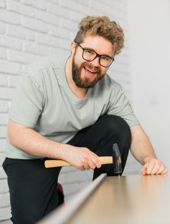 Young attractive man assembles furniture - handwerker and interior objects conceptの写真素材