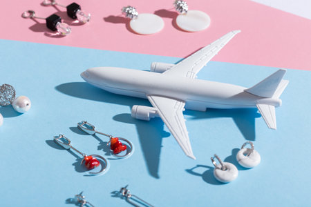 Modern minimalist handmade jewelry on blue and pink. Air plane toy for delivery and parcels on gift...