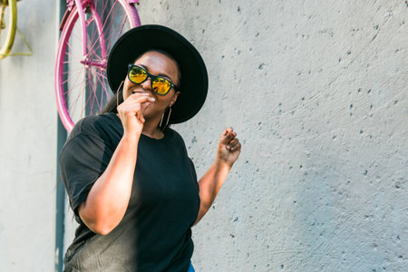 Joyful african american female listening to music in headphones and dancing merrily on street having fun, copy spaceの写真素材