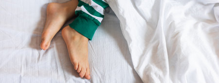 Banner child feet under the white blanket. Copy space and empty space for text, mockupの写真素材