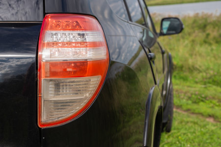 Back view of new black car. Closeup headlights of car. Black premium city crossover, luxury SUV rear light closeup. Car lamp close-upの写真素材