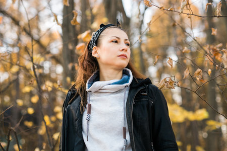 Outdoor atmospheric lifestyle portrait of young beautiful young woman copy space. Warm autumn fall...