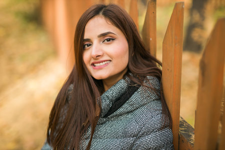 Close up portrait of pretty indian young woman enjoying warm autumn sunny day vacation outdoor copy space mockup. Generation z and gen z concept. Fall Seasonの写真素材