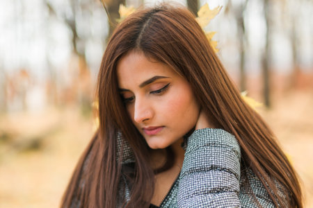 Close up portrait of pretty indian young woman enjoying warm autumn sunny day vacation outdoors. Generation z and gen z concept. Fall Seasonの写真素材