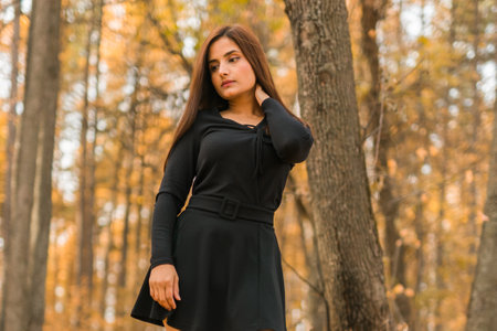 Close up portrait of pretty indian young woman enjoying warm autumn sunny day vacation outdoors copy space mockup. Generation z and gen z concept. Fall Seasonの写真素材