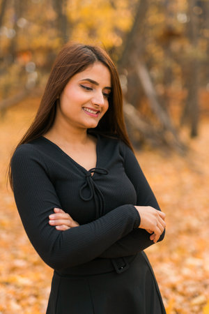 Close up portrait of pretty indian young woman enjoying warm autumn sunny day vacation outdoors. Generation z and gen z concept. Fall Seasonの写真素材
