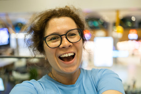 Video call portrait of excited cheerful smiling woman in spectacles taking selfie photo. Selfie and blogger conceptの写真素材