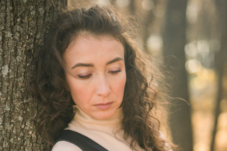 Portrait woman walking in autumn park, happy mood and fashion style trend and curly long brown hair copy space. Fall season and pretty female portrait copy space. Millennial generation conceptの写真素材