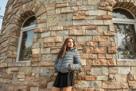 Portrait of diversity young beautiful confident Indian Asian woman in fall season brick building background. Happy and natural smiling female. Generation z and gen z youth conceptの写真素材