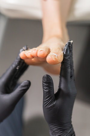 Woman doing foot peeling in pedicure SPA salon. Sugar scrub and relax beauty procedureの写真素材
