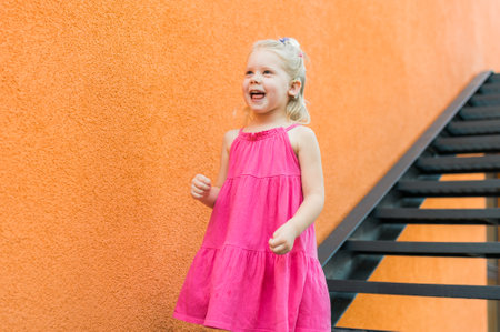 Child girl with hearing aids and cochlear implants having fun outdoor speak and playing. Copy space...