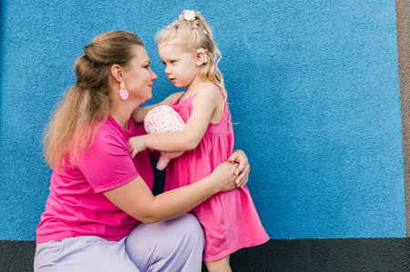Child girl with cochlear implant with her mother spend time outdoor. Hear impairment and deaf community concept. Deaf and health concept. Diversity and inclusion. Copy spaceの写真素材