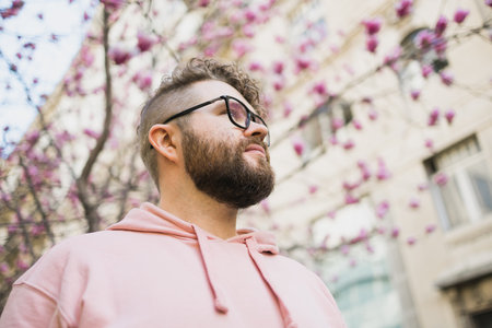 Spring fashion style. Male sexuality. Bearded man portrait on blooming flower tree background. Enjoy...