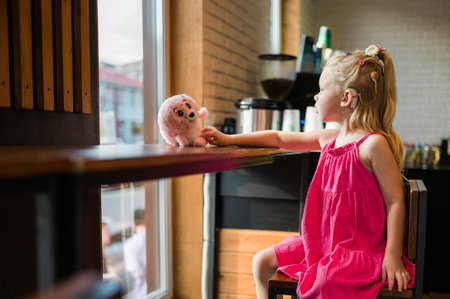 Funny child with cochlear implant in cafe. Hearing aid and medicine innovating technology concept. Diversity and inclusion. Copy spaceの写真素材