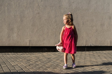 Child girl walks and have fun outdoor with cochlear implant on the head. Hearing aid and treatment concept. Copy space vertical. Inclusionの写真素材