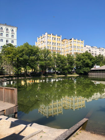 Patriarch ponds reflecting surrounding architecture on a clear summer day in Moscow city....