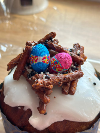 Festive easter cake is decorated with colorful chocolate eggs and crunchy pretzel sticks, creating a...