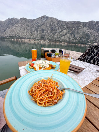 Delicious plate of pasta overlooking a tranquil mountain lake setting. Perfect blend of culinary...