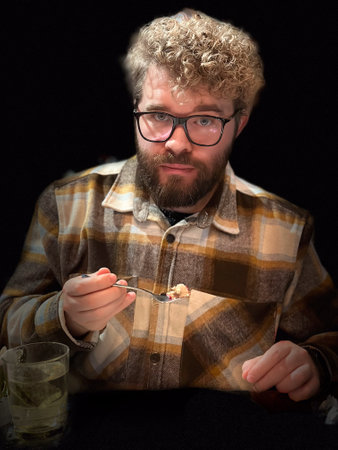 Millennial man casual dining experience with cozy flannel shirt and warm beverage in a relaxed setting, emphasizing the simple joys of eating outの写真素材