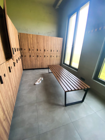 Wooden bench in empty locker room at gym