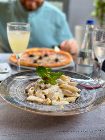 Savoring delicious italian cuisine at an elegant al fresco dinner. Beauty and pleasure of enjoying fine dining in a relaxed outdoor settingの写真素材