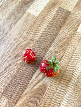 Two fresh strawberries on wooden tableの写真素材