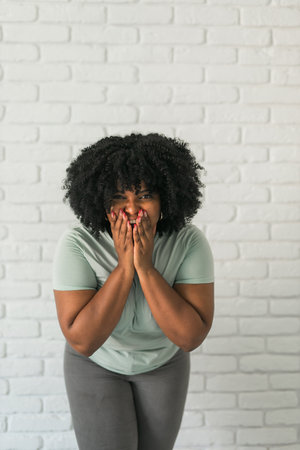 African American woman expressing pure joy with an enthusiastic and open expression. Excitement, energy and contagious sense of positivityの写真素材