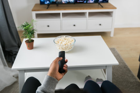 Remote control is pointed toward the television screen, control and choice of tv entertainment. TV, series and streaming service conceptの写真素材