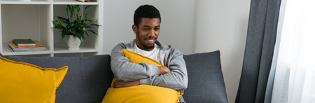 Banner african american male in casual clothes resting at home on comfortable sofa while watching tv channels or movie during weekend. Tv set, online television and entertiment technologies. Copy spaceの写真素材