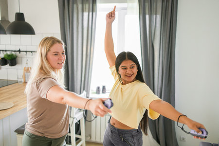 Cheerful group of friends playing video games together at home, leisure and entertainment conceptの写真素材