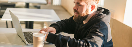 Close-up banner male guy portrait resting in coffee shop chatting in social networks skilled freelancer enjoying remote job typing publication for web blog on laptop copy spaceの写真素材