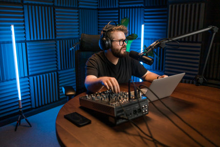 Young smiling male radio presenter talking into the microphone. Podcast and internet streaming concept.の写真素材