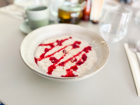 Oatmeal with berry drizzle on restaurant table. Healthy eating, minimalist style and natural breakfast choicesの写真素材