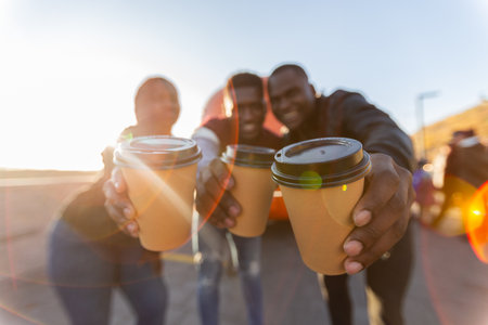 Group of african american friends making coffee toast at sunset. Concept of friendship, celebration, joyful lifestyle moments.の写真素材