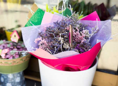 Bouquet of dried flowers in pink wrapping. Mixed lavender, pink, and lilac stems arranged in decorative packaging.の写真素材