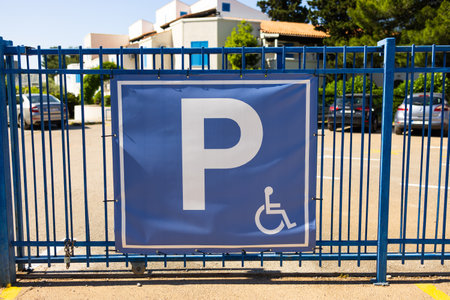 Parking sign on blue gate. Urban accessibility, transportation regulation, and inclusive infrastructure in public spacesの写真素材