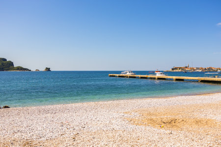 ier and boats near coastal town. Seaside tourism, marine transport, and scenic view of Budva in Montenegro.の写真素材