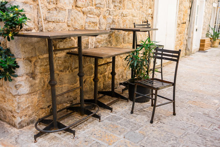 Empty wicker chairs in outdoor cafe. Hospitality service, seasonal tourism, and summer leisure in public spaces.の写真素材