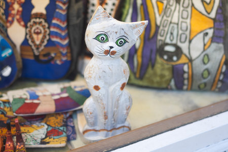 Wooden cat figurine in shop window. Handcrafted toy and folk art concept.の写真素材