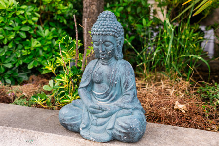 Buddha statue on a table in a peaceful outdoor setting. Meditation, serenity, and spiritual decor in public space.の写真素材