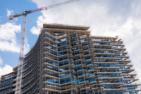 Construction site with tower crane against the sky. Concept of modern architecture, civil engineering, and urban development.の写真素材