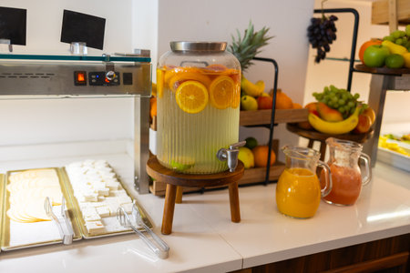 Fruit drinks and sliced cheeses on breakfast buffet table. Refreshment station, healthy beverage option, and fresh dairy assortment concept.の写真素材