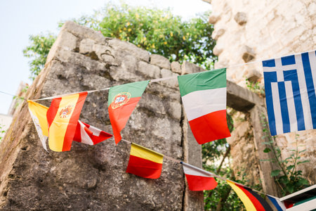 String of international flags in a Mediterranean alley. Cultural diversity, travel spirit, and...